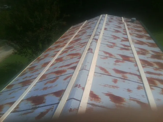 Rusted metal roof panels with new wood purlins before replacement — Storm Damage Roof Repair in Edgar by Roofing Brothers